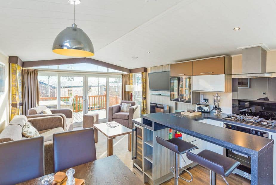 Lodge open-plan kitchen and living area with sofas, breakfast bar and patio doors