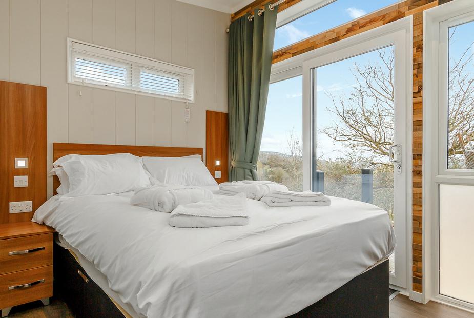 Lodge bedroom with double bed and sliding glass doors to balcony