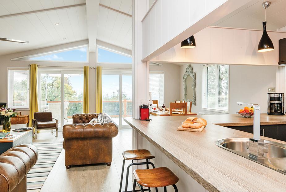 Lodge open-plan kitchen with breakfast bar and lounge area with leather sofas