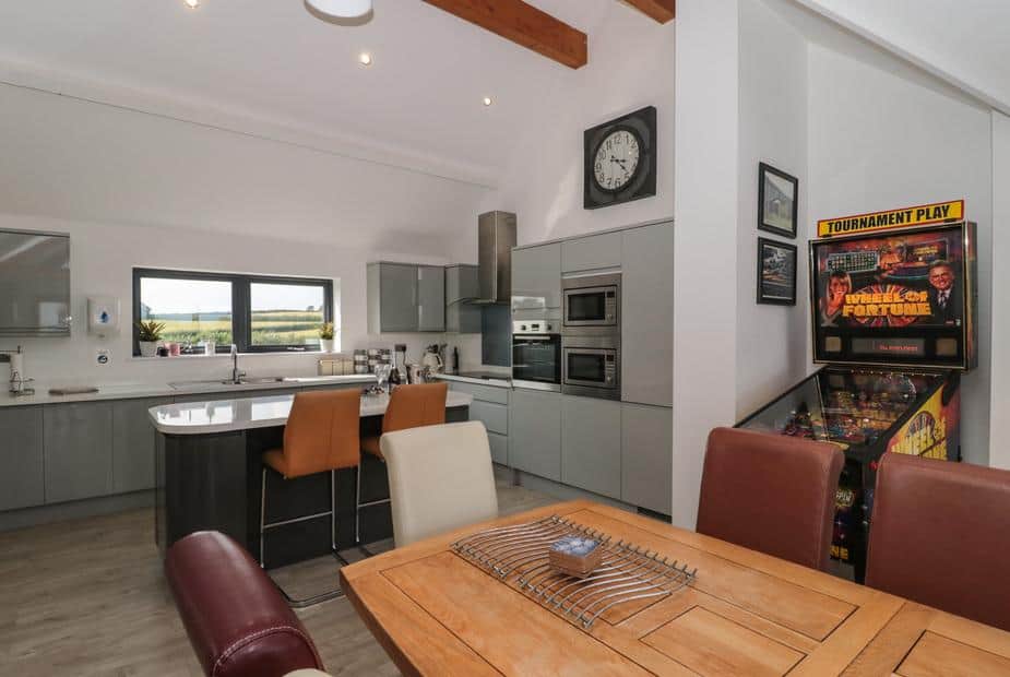 Cottage kitchen with breakfast bar and Wheel of Fortune pinball machine