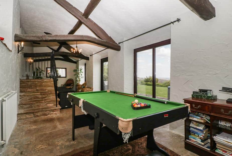 Cottage games room with pool table and sliding glass doors to the garden