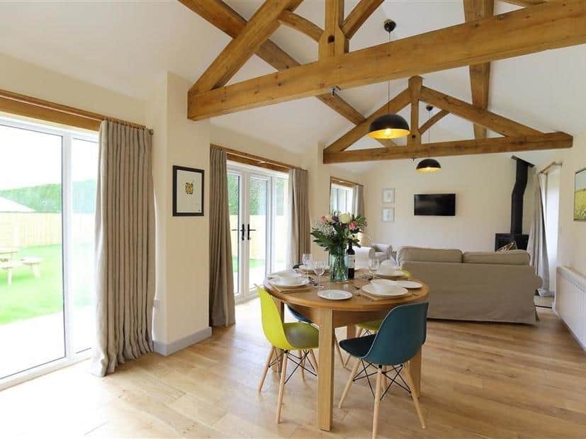 Cottage dining area with round table and exposed wooden ceiling beams