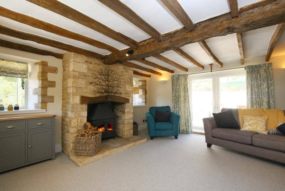 Cottage living room with exposed beams and stone fireplace