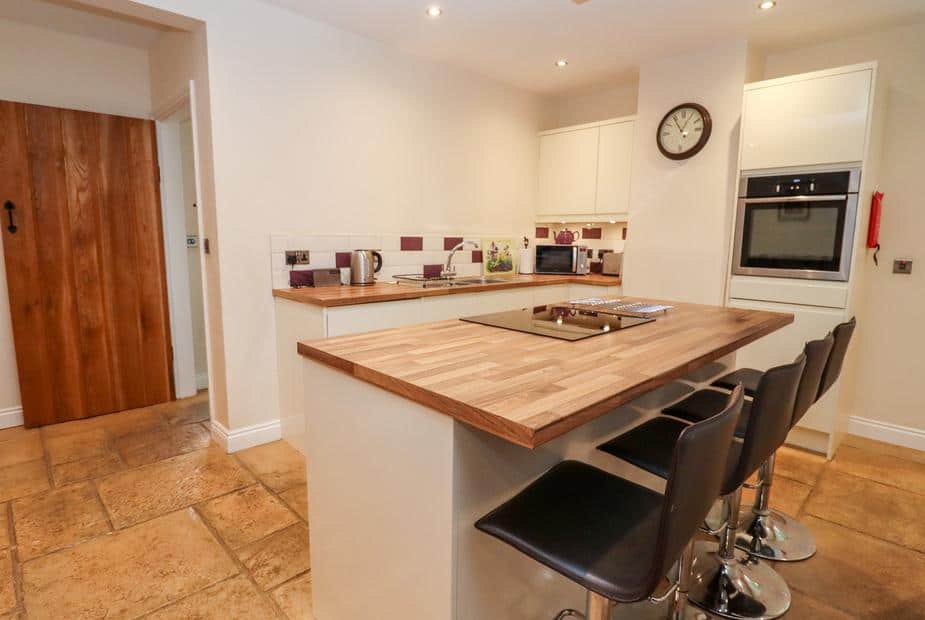 Kitchen with island hob and bar stools