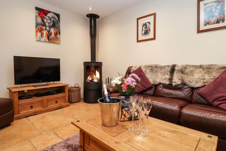 Cottage lounge with log burner, leather sofa and TV