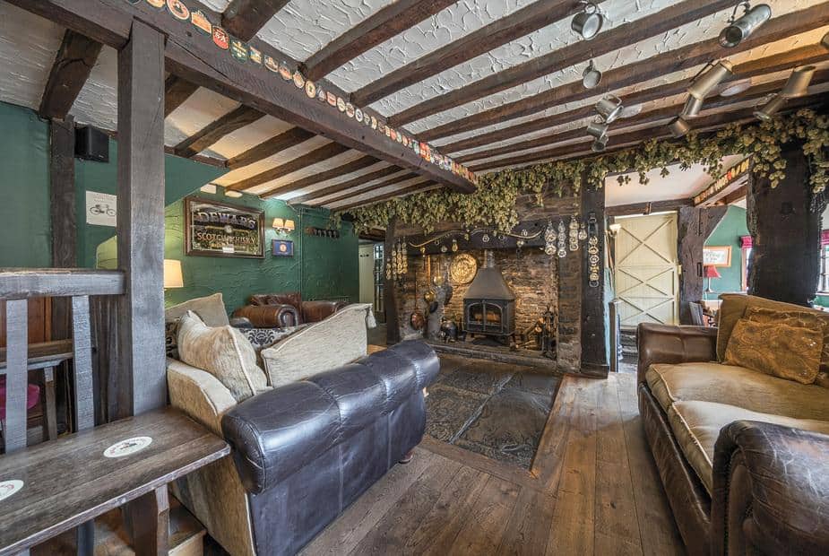 Cottage living room with exposed beams and log burner fireplace