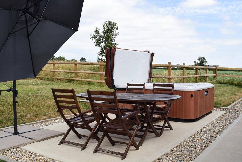 Outdoor seating and hot tub on patio at Waxwing Cottage with countryside views