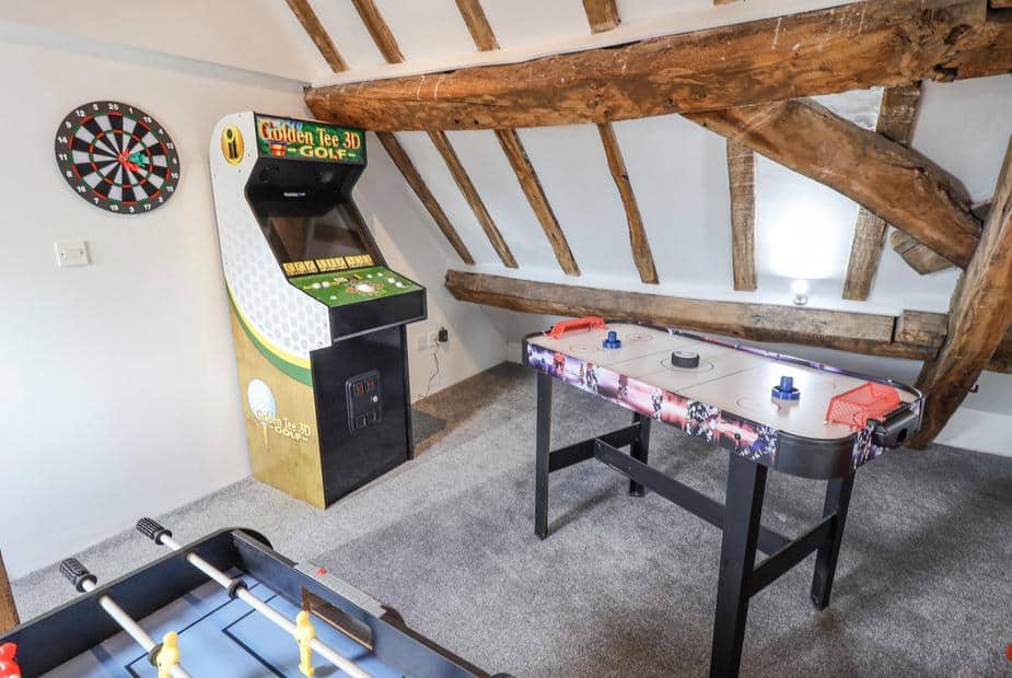 Cottage games room with arcade machine, air hockey table and dartboard
