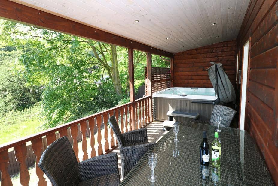 Lodge covered deck with rattan dining set and hot tub