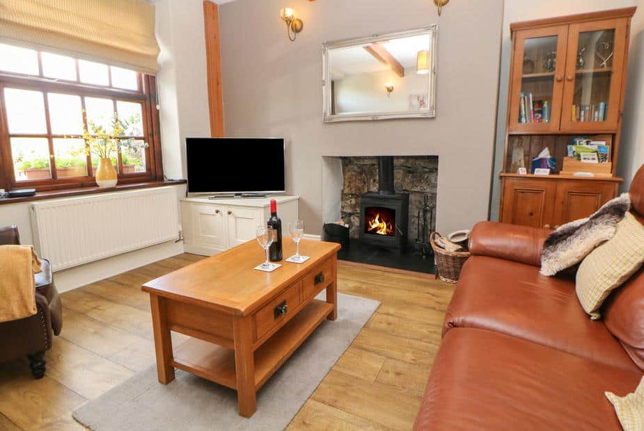 Cottage lounge with leather sofa and woodburner fireplace