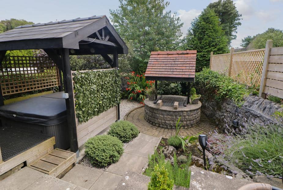 Cottage garden with covered hot tub and stone wishing well
