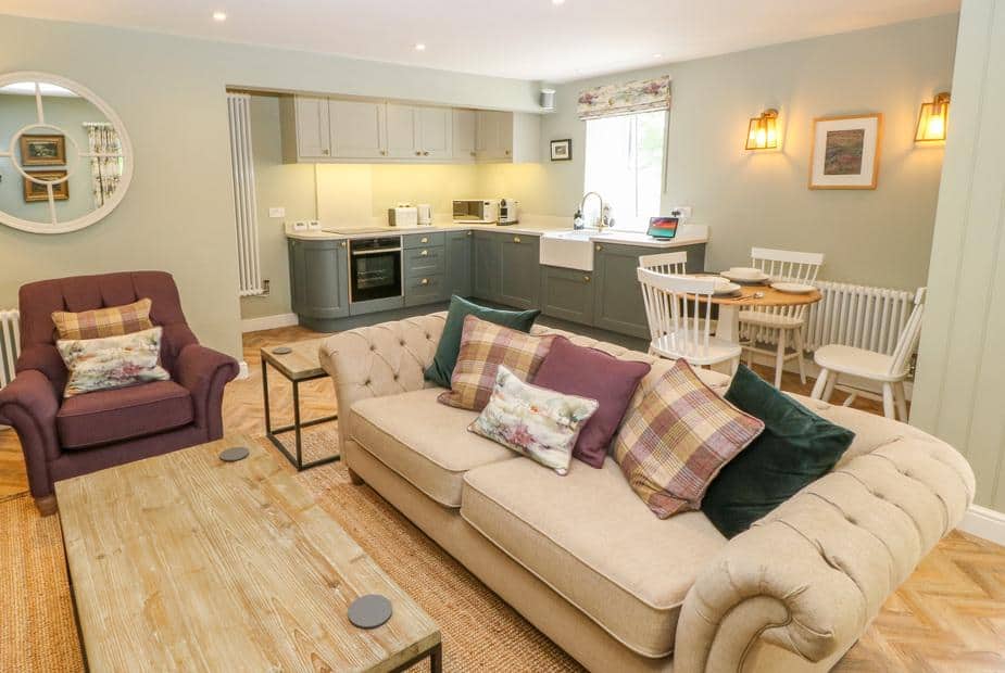 Cottage open-plan living area with sofa, armchair, kitchen and dining table