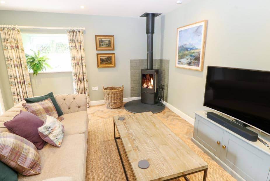 Cottage lounge with wood burner, sofa, television and coffee table