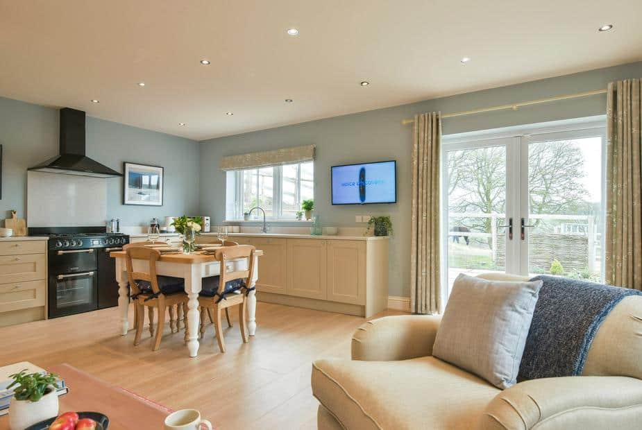 Cottage kitchen and dining area with table, chairs and French doors to garden