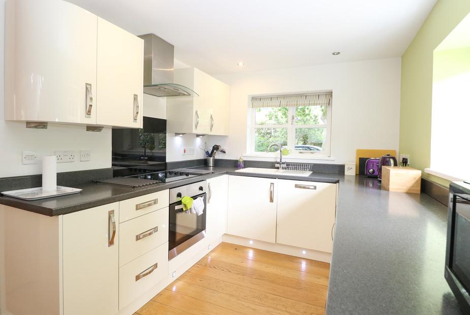 Lodge kitchen with white cabinets, electric hob and window above sink
