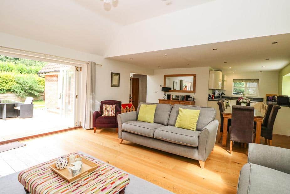 Lodge lounge with sofa, open-plan kitchen and dining area, doors to patio garden