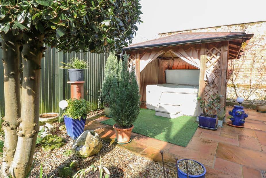 Lodge garden with covered hot tub and potted plants