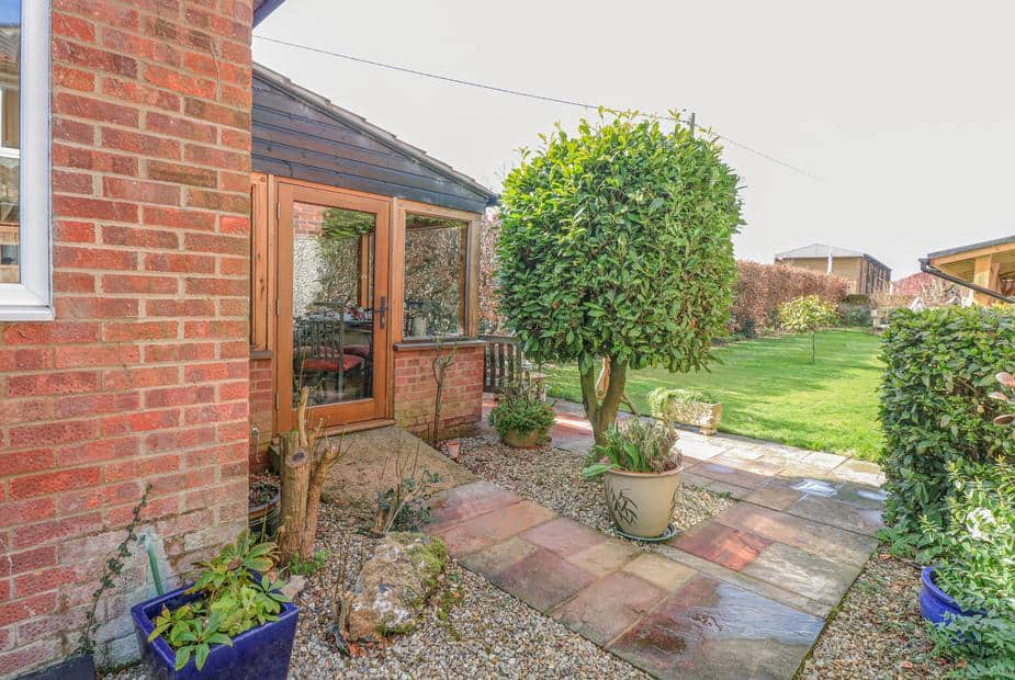 The Lodge patio with potted plants and lawn area visible through glass doors