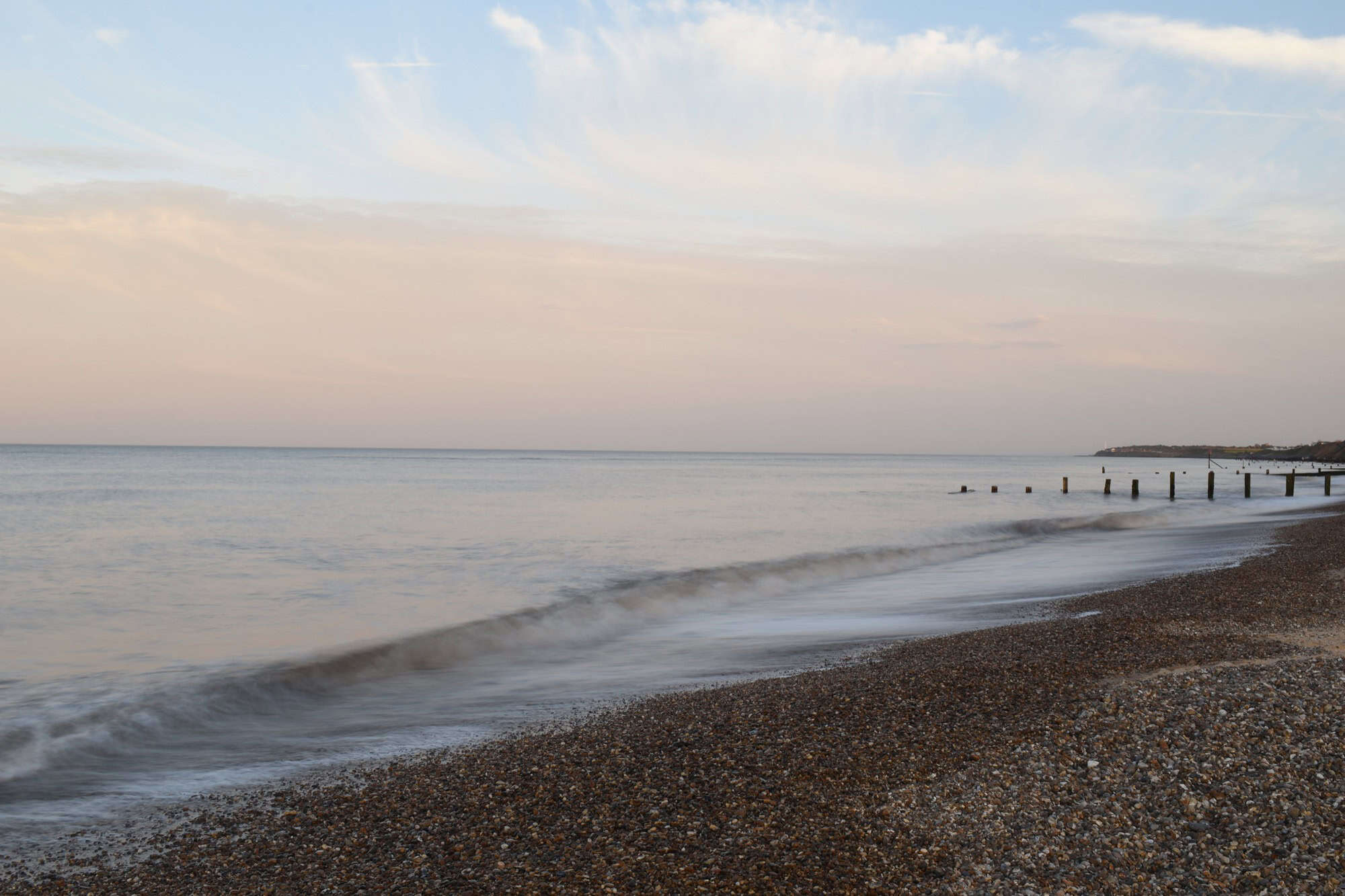 Soft sunset light reflecting on the calm waves and sandy shore of Gorleston Beach, near Great Yarmouth.