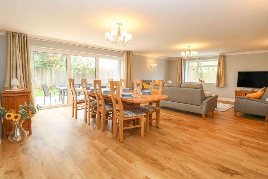 Cottage open-plan lounge and dining area with wooden table and grey sofas