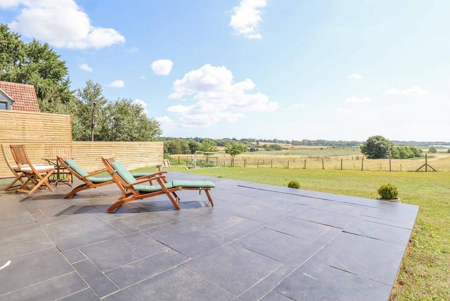 Patio at cottage with sun loungers overlooking open countryside
