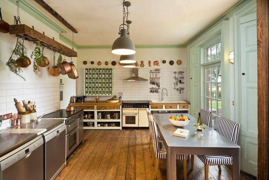 Cottage kitchen with wooden floor, dining table and hanging pots