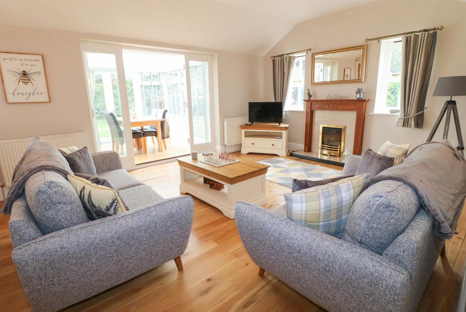 Living room with sofas, coffee table and fireplace, view to dining area