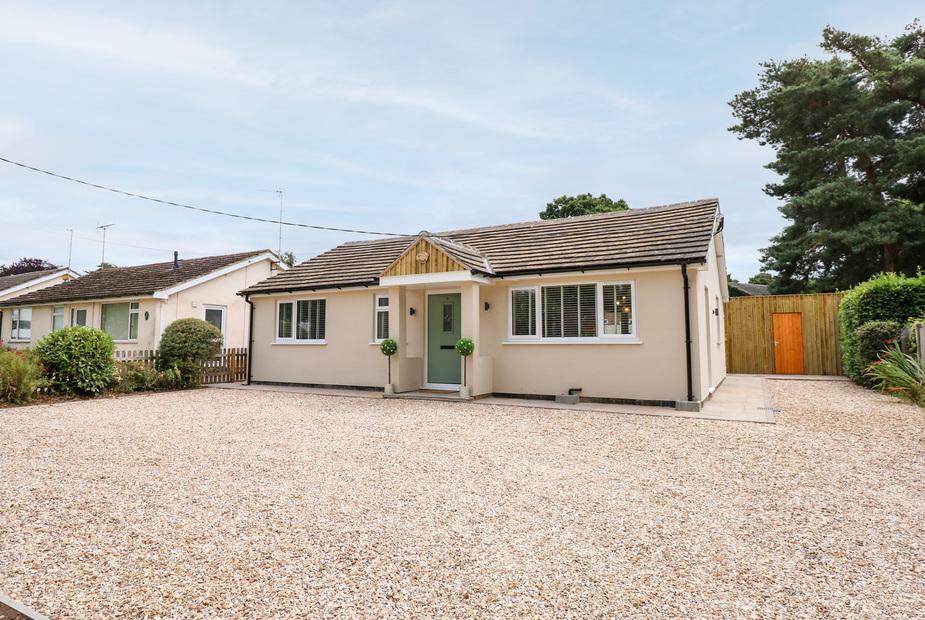 Daisy Tree Cottage with gravel driveway and light green front door