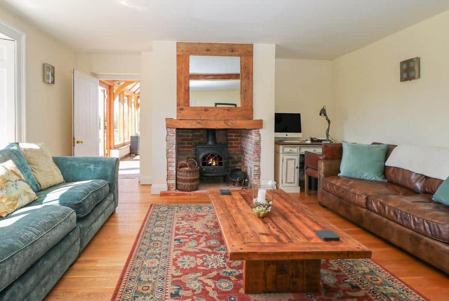Cottage lounge with wood-burning stove, sofas and wooden coffee table