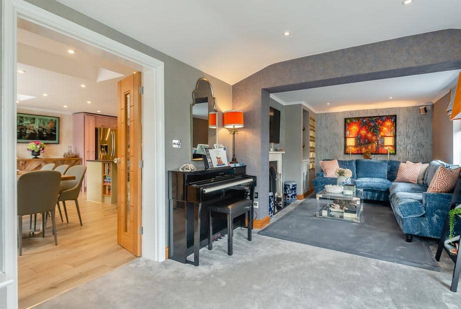 Cottage living room with piano and blue corner sofa