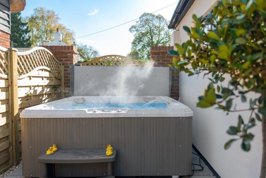 Cottage garden with outdoor hot tub and steam rising
