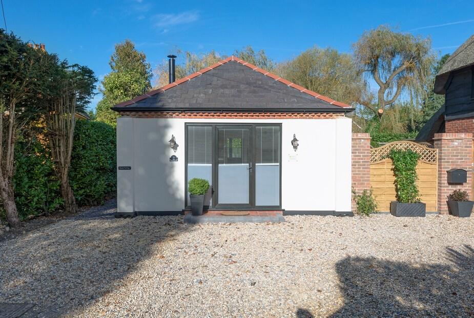 The Old Meeting Hall with gravel drive and central glass door entrance.