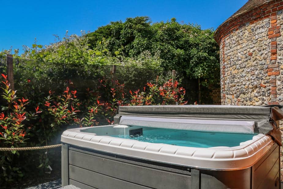 Hot tub beside stone wall and plants