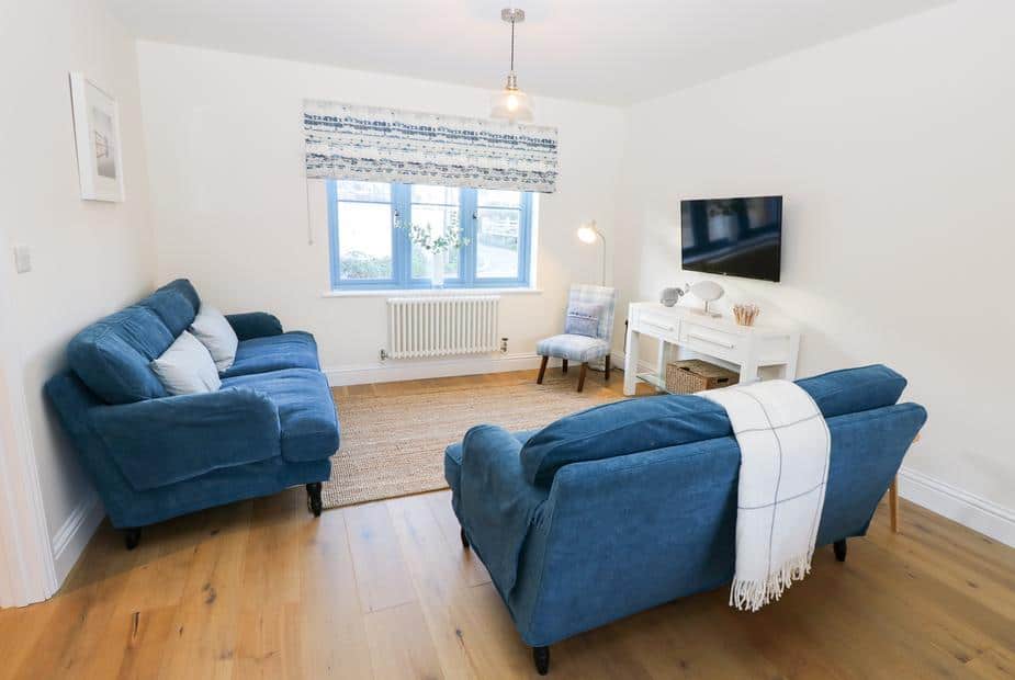 Cottage living room with two blue sofas and wall-mounted television