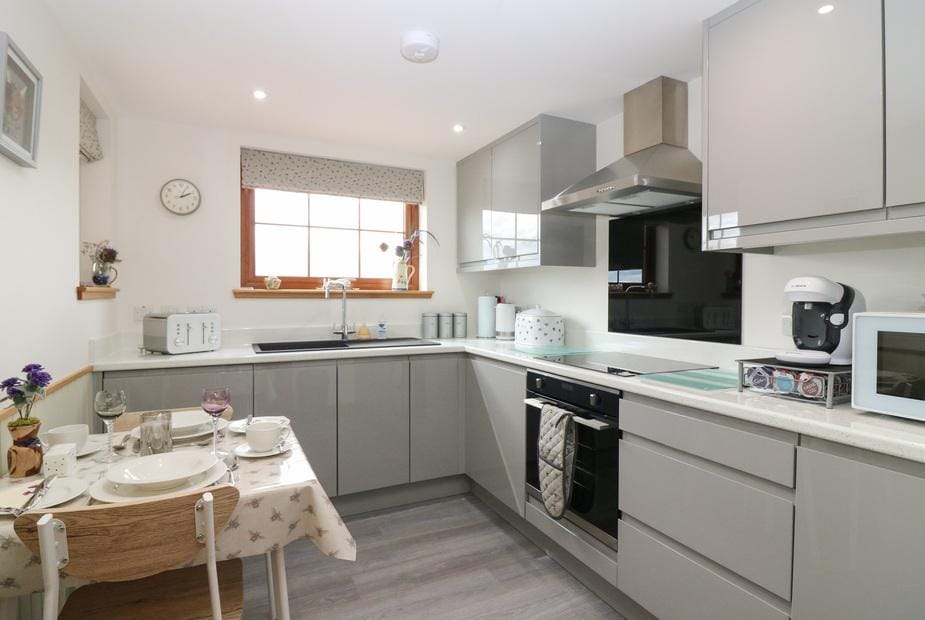 Kitchen with modern cabinets, oven and small dining table set for two