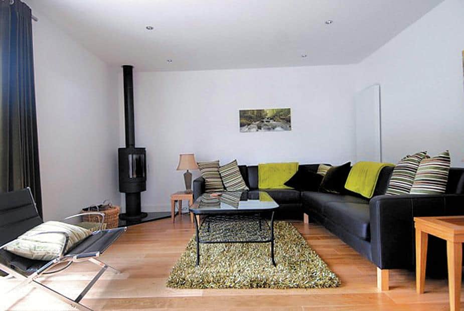 Cottage living room with corner sofa, glass coffee table and log burner