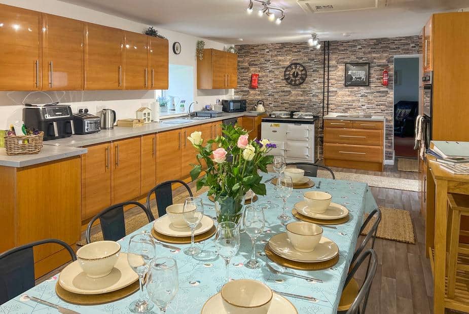 Cottage kitchen with dining table set for eight and wood cabinets