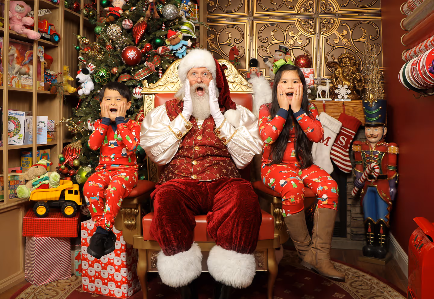Festive Santa picture with two siblings on a gold throne chair, all with shocked silly faces
