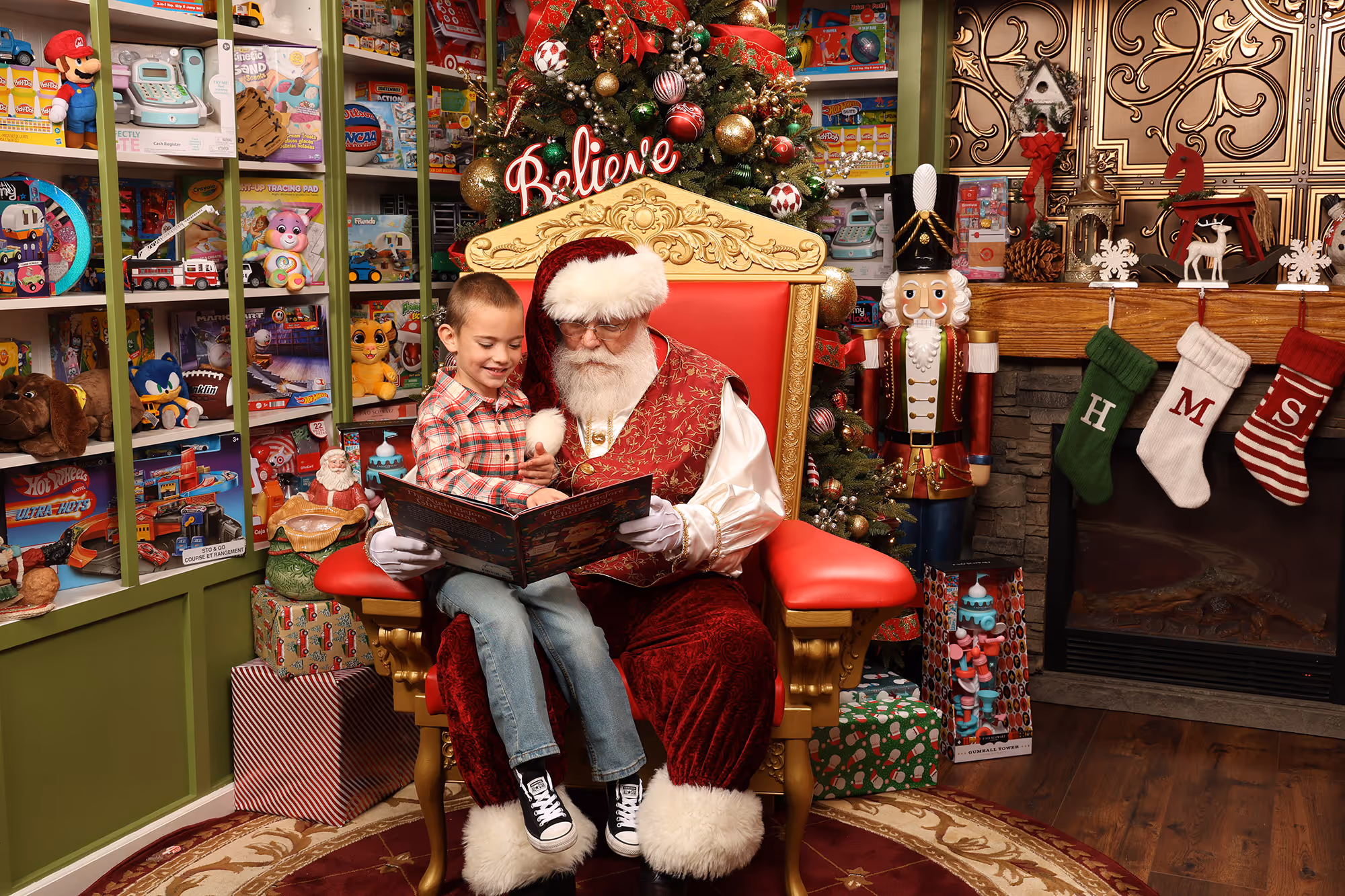 Santa reading 'Twas the Night Before Christmas to a boy in a festive room