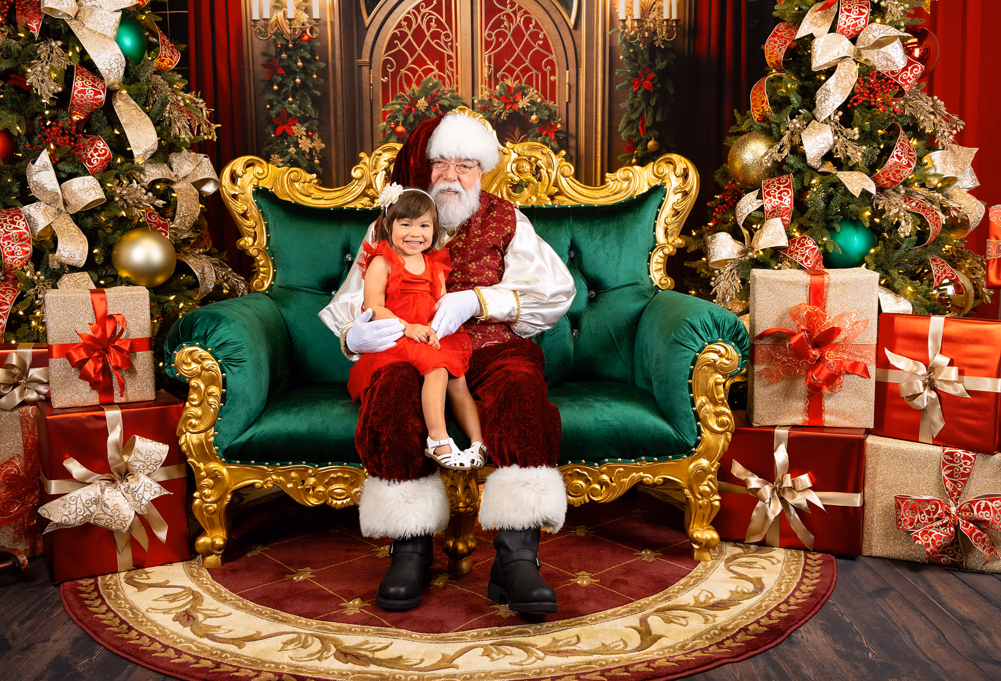 Little girl smiling on Santa's lap in Christmas-themed photography studio