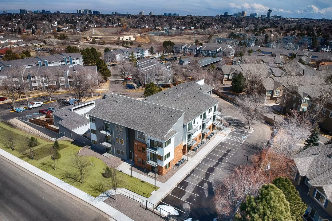 Wide aerial view of the Villas at Holly apartment complex, showing multiple buildings, parking areas, and green spaces in Centennial, CO.