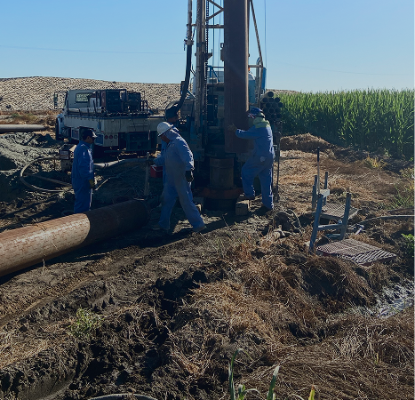 Irrigation well drilling. Crew sets casing for a well used for irrigating crops.