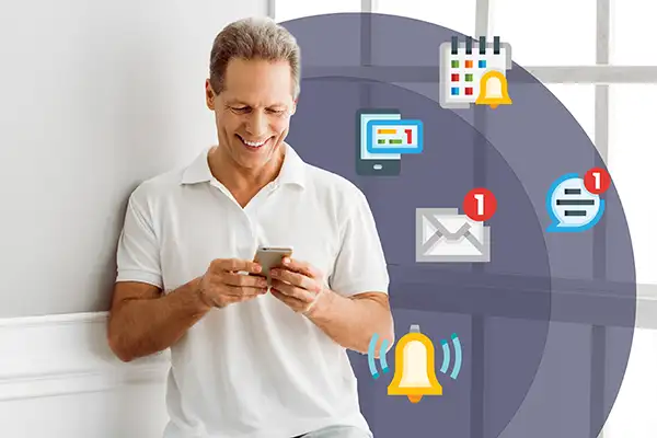 Middle-aged man in white shirt smiling and using smartphone surrounded by notification icons including email, calendar, chat, and alerts.