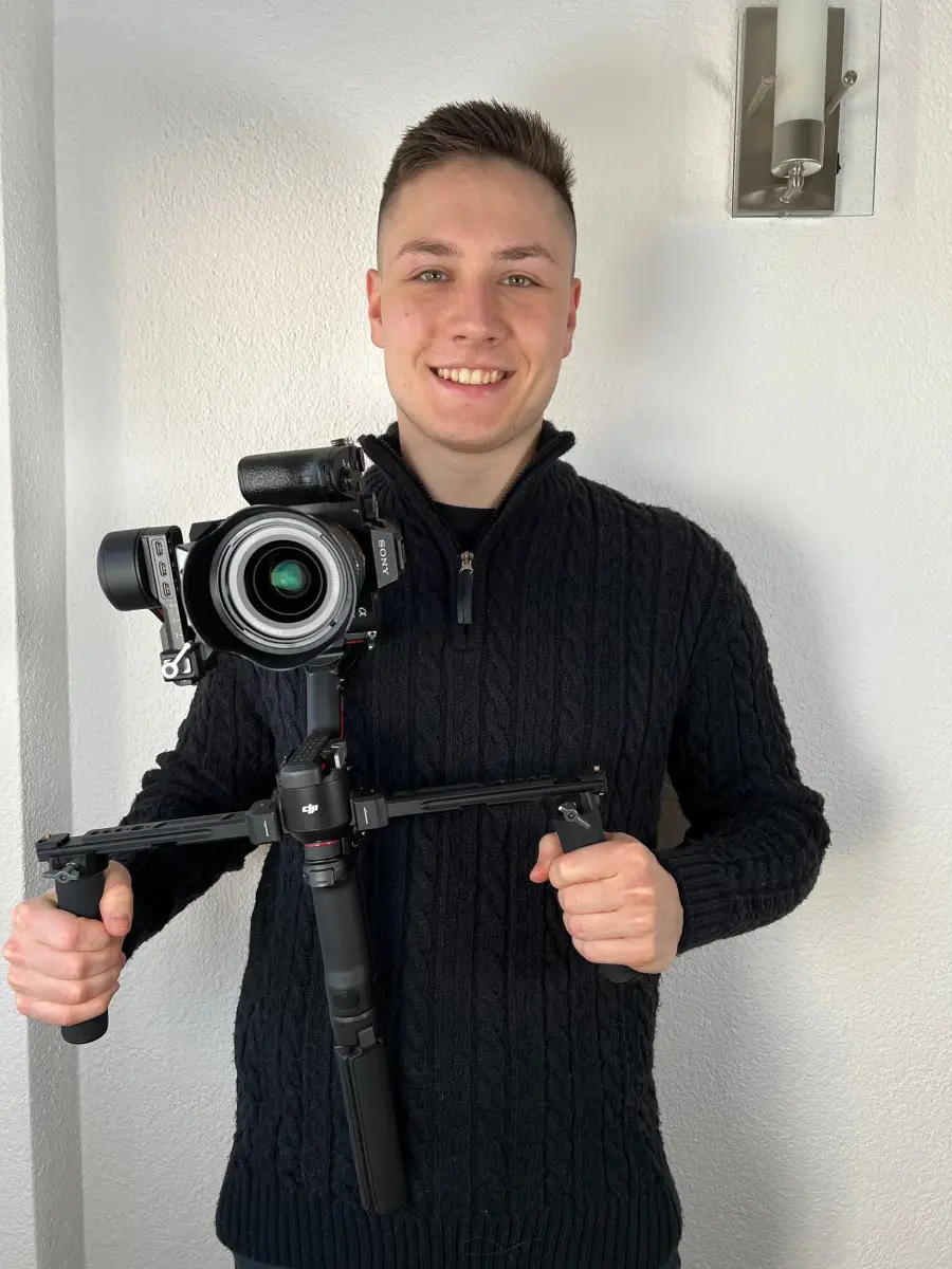 Chris Sygo mit Kamera und Gimbal vor einem Videodreh