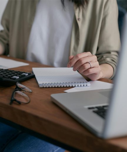 a person sittling at a table with a notebook