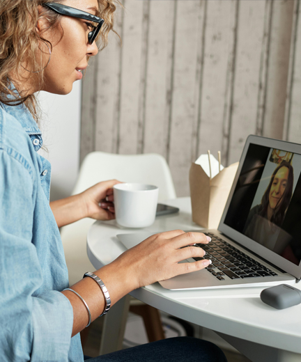 a woman looking at a computer screen for a video conference.