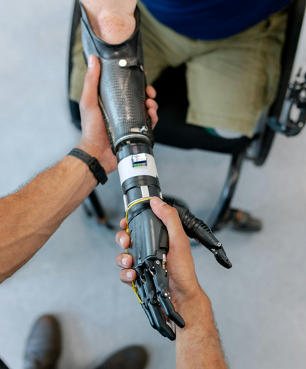 a man grasping a prosthetic hand