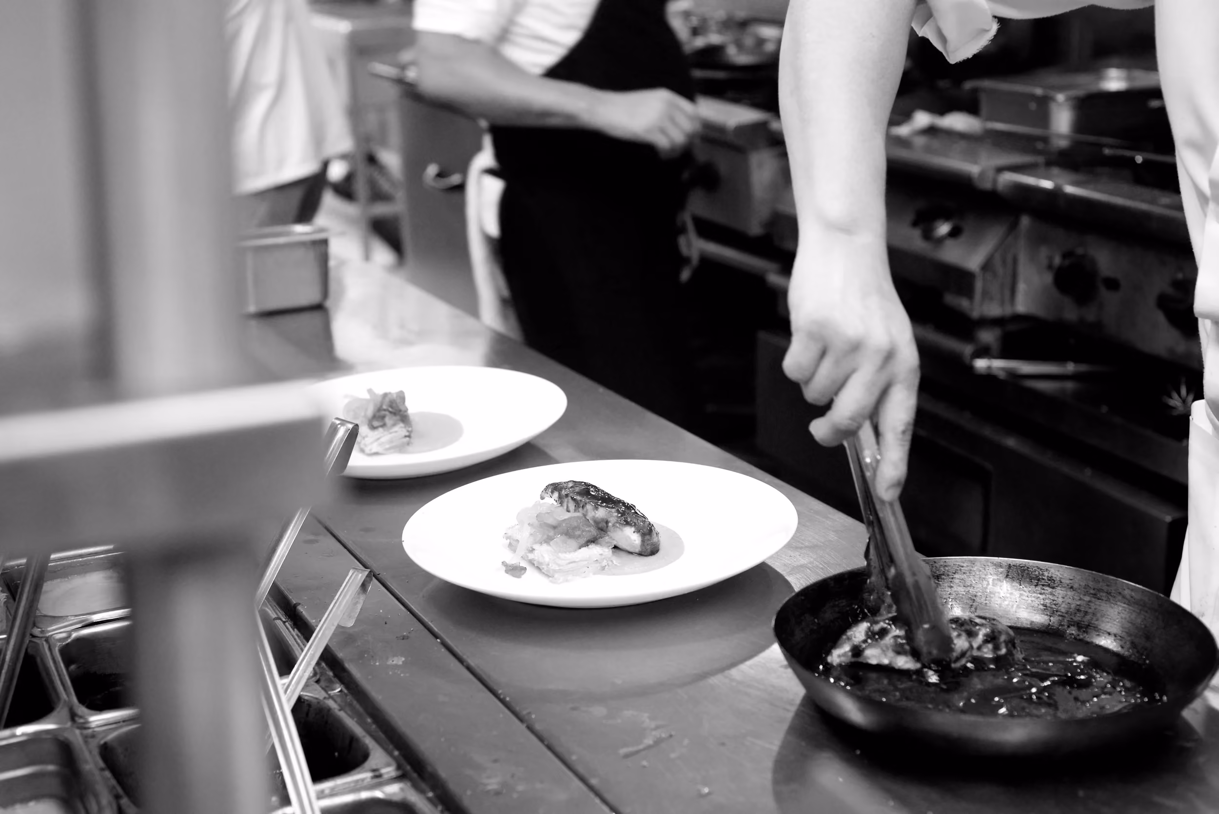 A chef plating dishes on the pass in the La Palapa kitchen