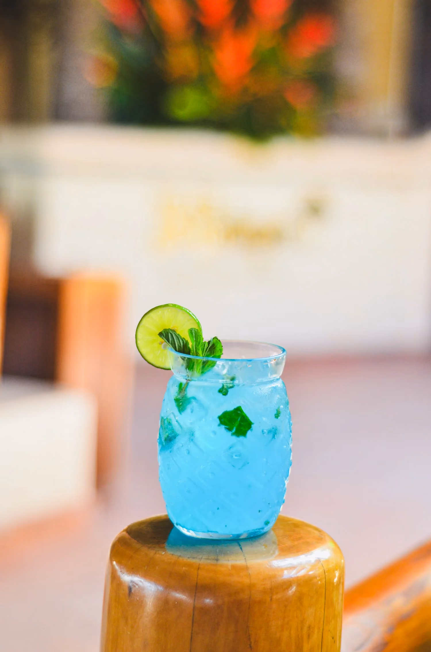 A blue cocktail garnished with mint and lime
