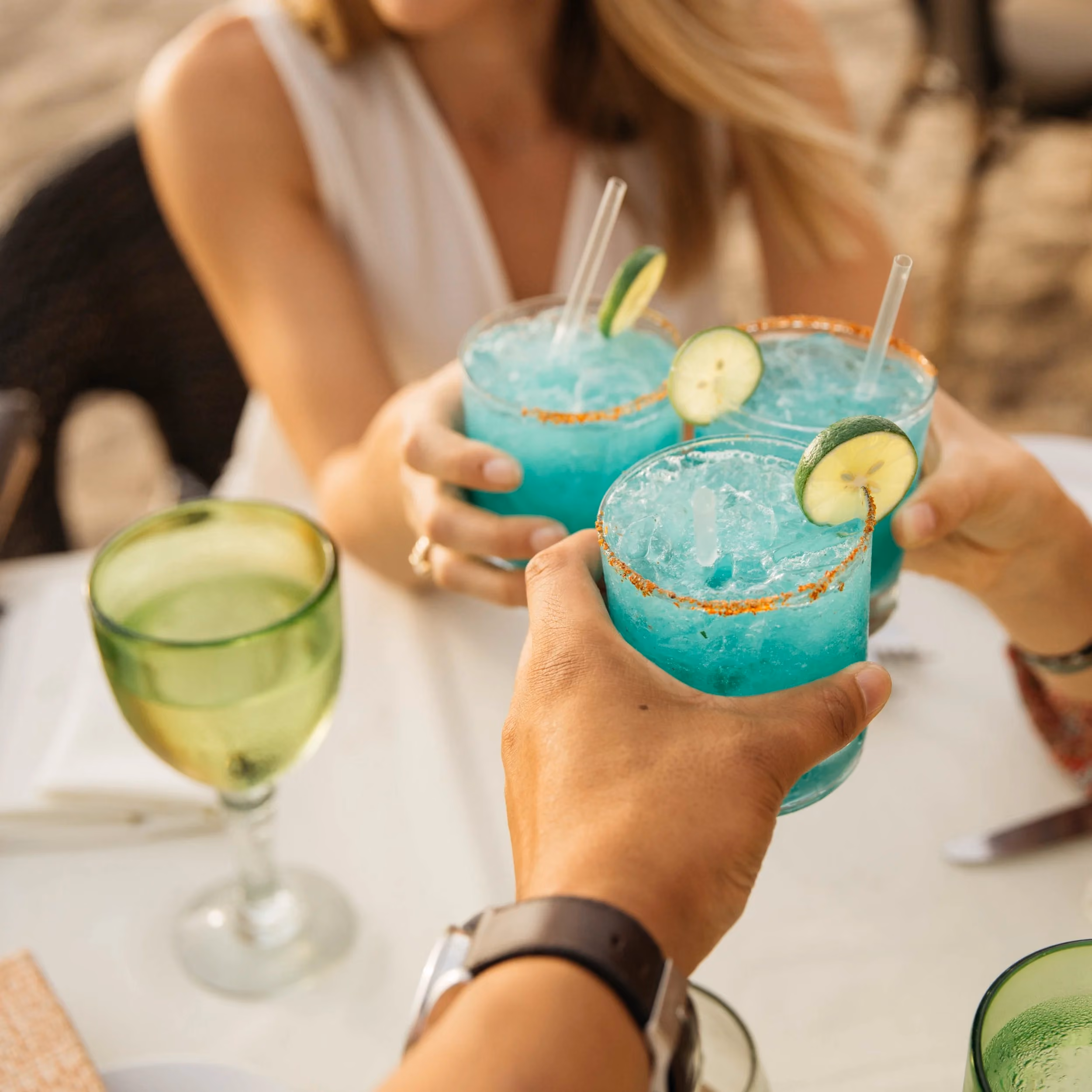 Friends toasting with blue cocktails